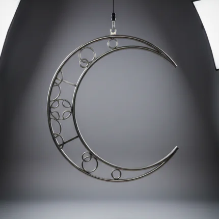 Professional volumetric aerial moon lyra made of polished stainless steel, featuring a decorative internal truss design, hanging in a bright white photo studio.